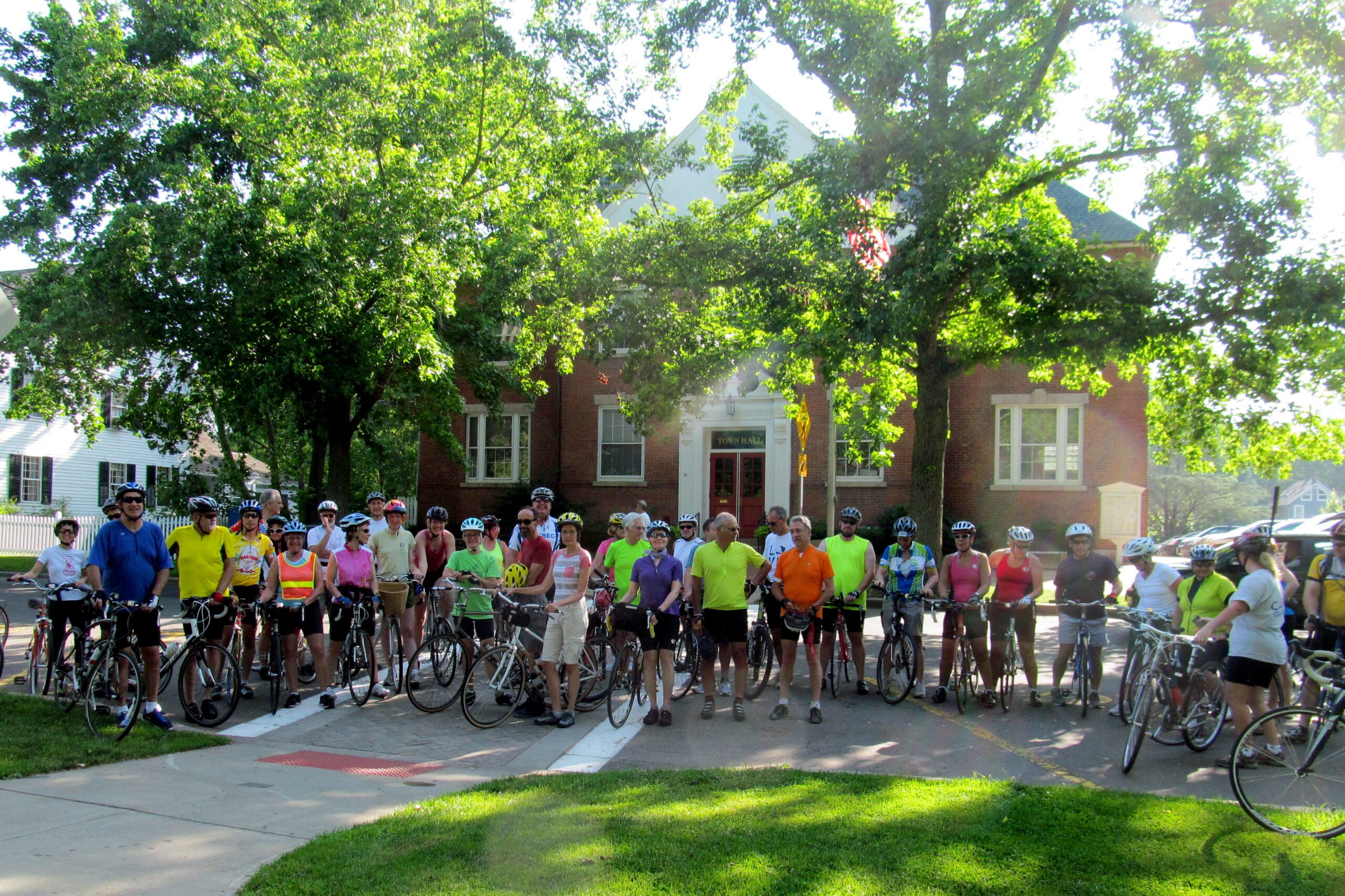 On the Guilford Town Green, enthusiastic bicylists gather for a Shoreline Greenway Trail 1st Saturday bike ride to Lake Quonnipaug during the Fourth of July weekend, with SGT leaders Terry and Martha Maguire, and Ted Braun.